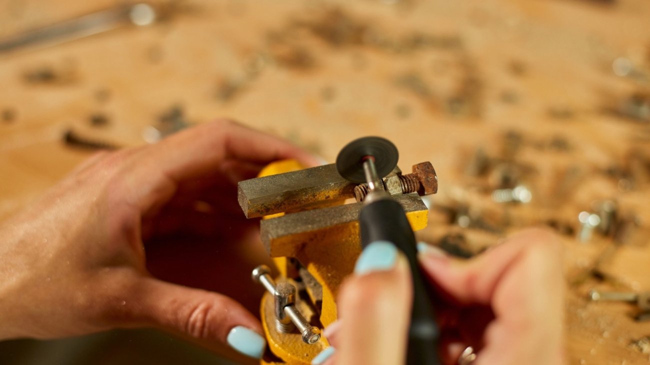 worker-hands-holds-detail-lathe-on-background-GYT